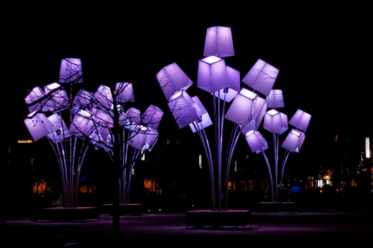 Stunning outdoor light installation in Valence, France, featuring purple illuminated structures against a night sky.